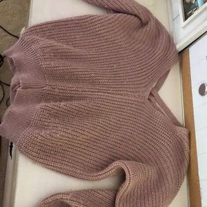 a pink knitted sweater with cross backing
